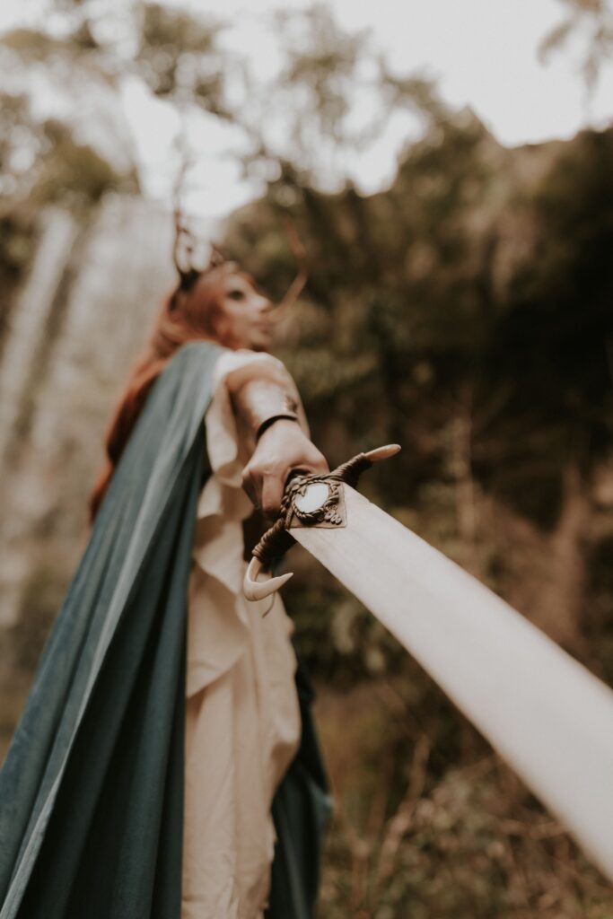 Fantasy warrior with sword in a mystical forest setting, showcasing adventure and courage.